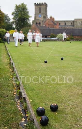 People playing crown green bowls in a English village